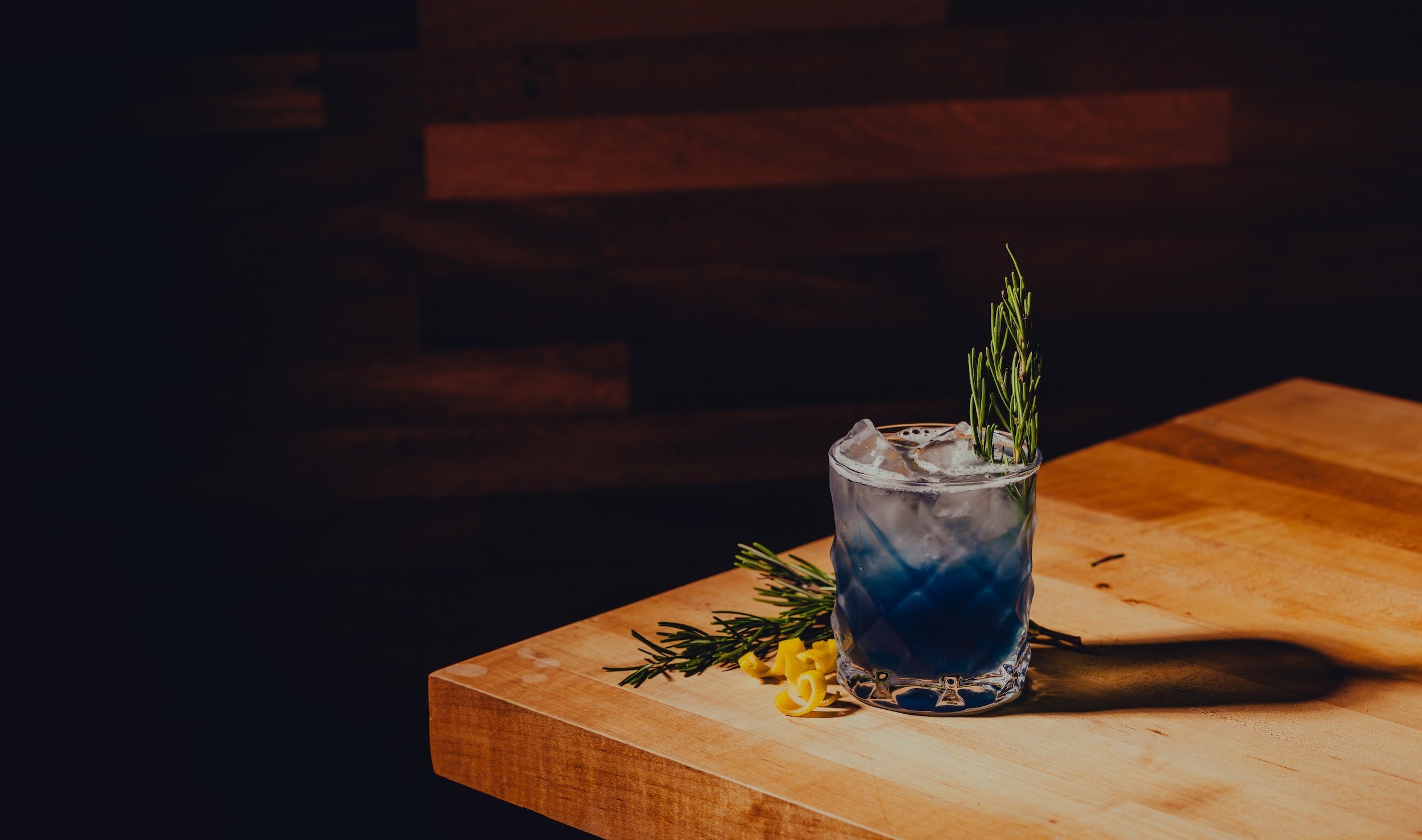 Blue cocktail on wood table by Zero Non-Alcoholic Bar